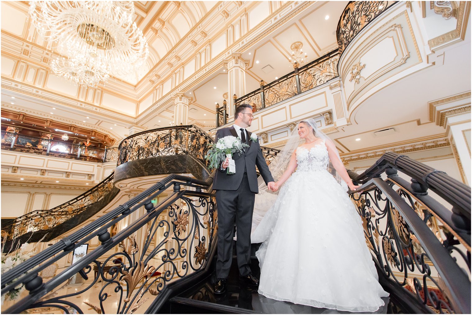 bride and groom descend stairs during portraits with Idalia Photography