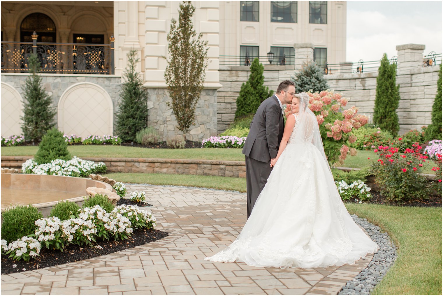 groom kisses bride on forehead during portraits at Legacy Castle with Idalia Photography