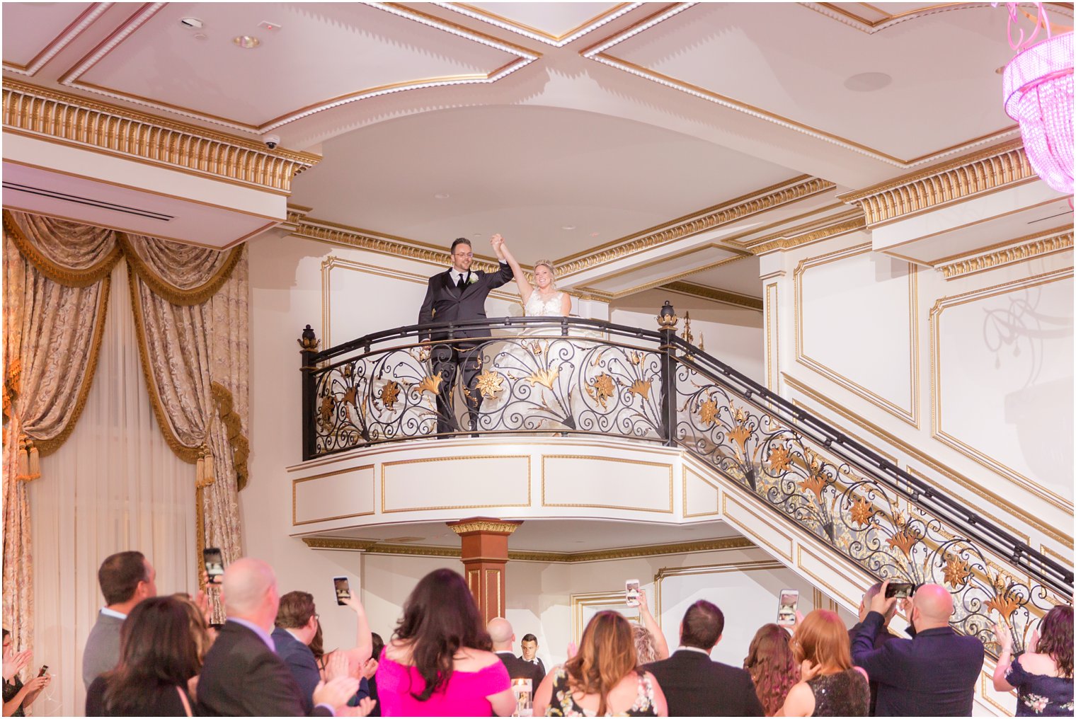 bride and groom enter reception at Legacy Castle on staircase by Idalia Photography