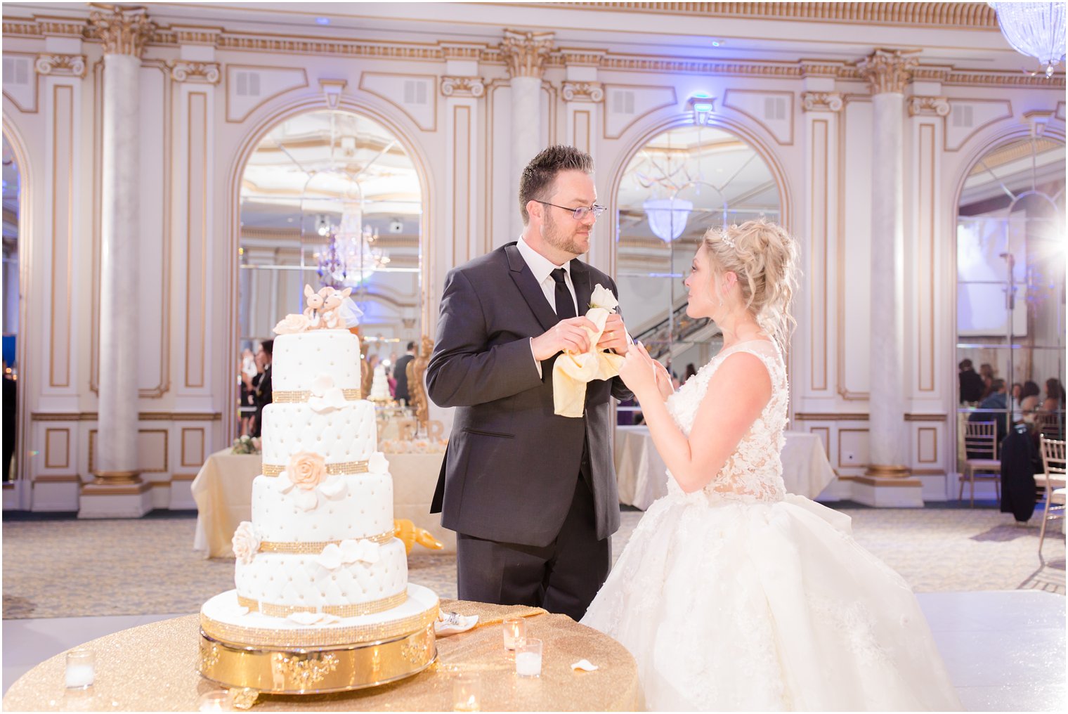 bride and groom remove kangaroo wedding toppers from Calandra's Bakery wedding cake 