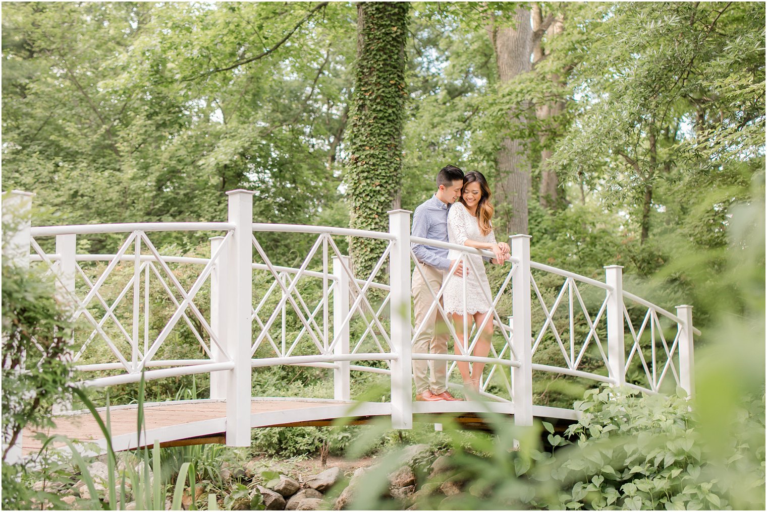 bride and groom on bridge at Sayen House and Gardens engagement session with Idalia Photography