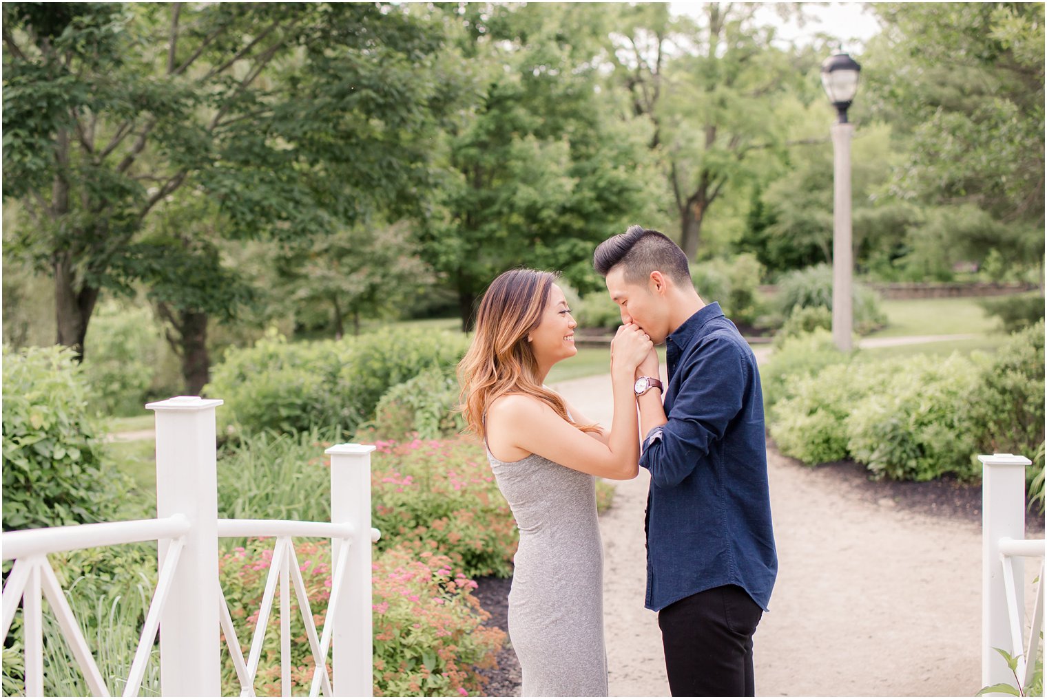 groom kisses brides hand during engagement session at Sayen House and Gardens with Idalia Photography