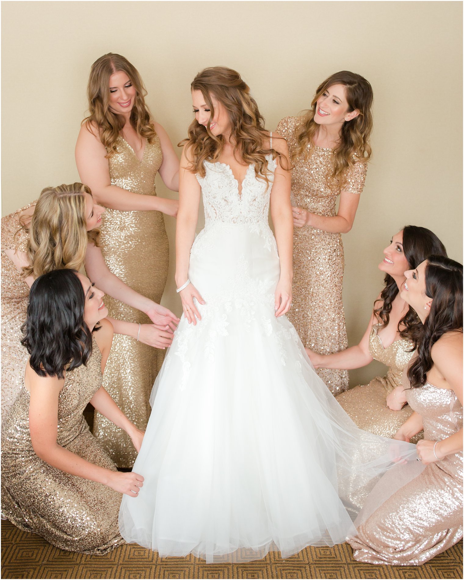 bridesmaids helping bride get dressed