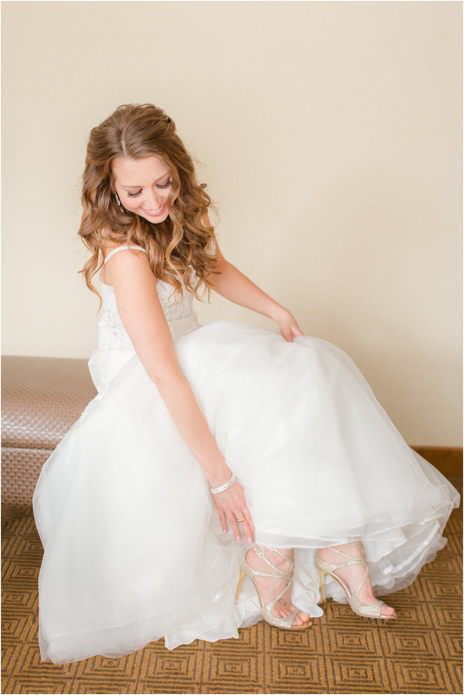 bride putting on gold Jimmy Choo shoes