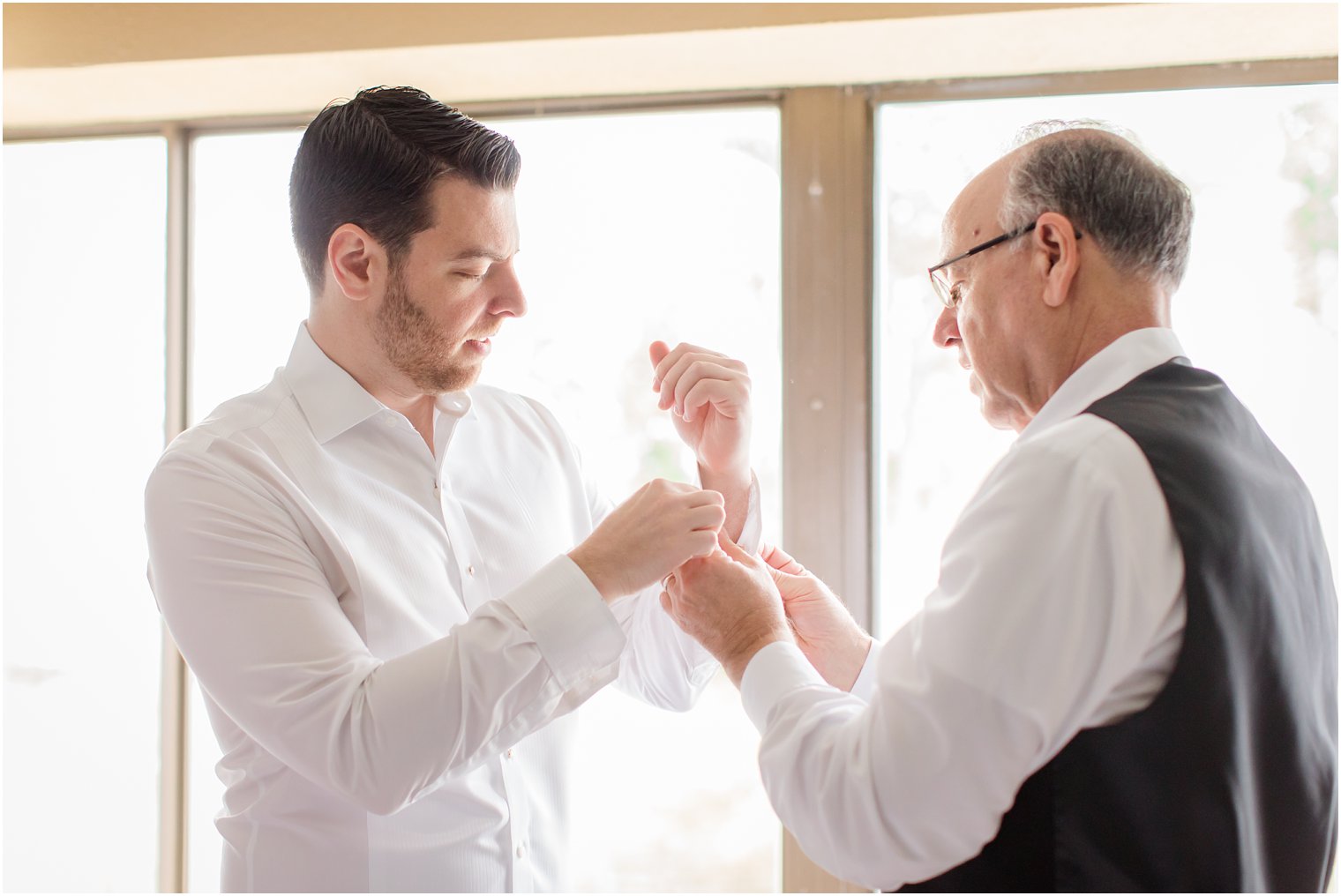 groom's father helping him put on cufflinks