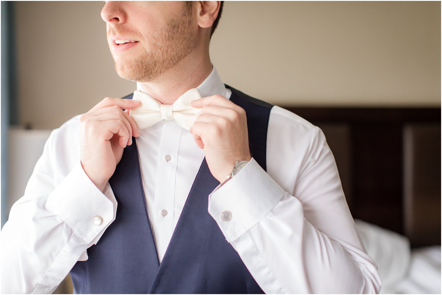 groom fixing his bow tie