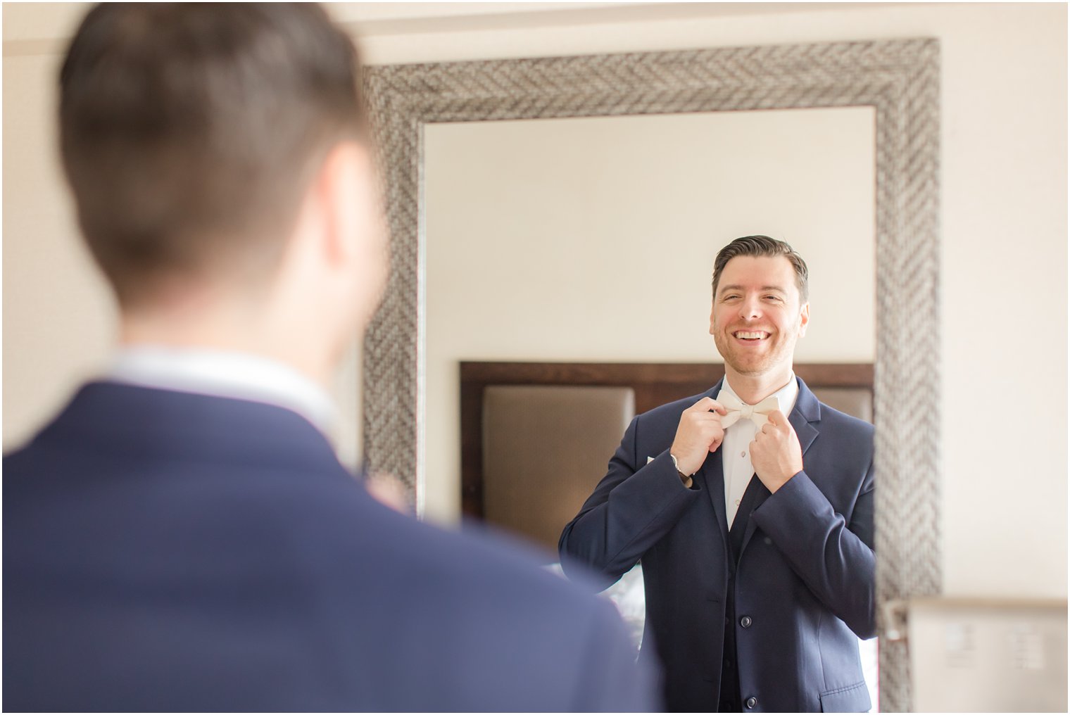 groom putting on his bow tie