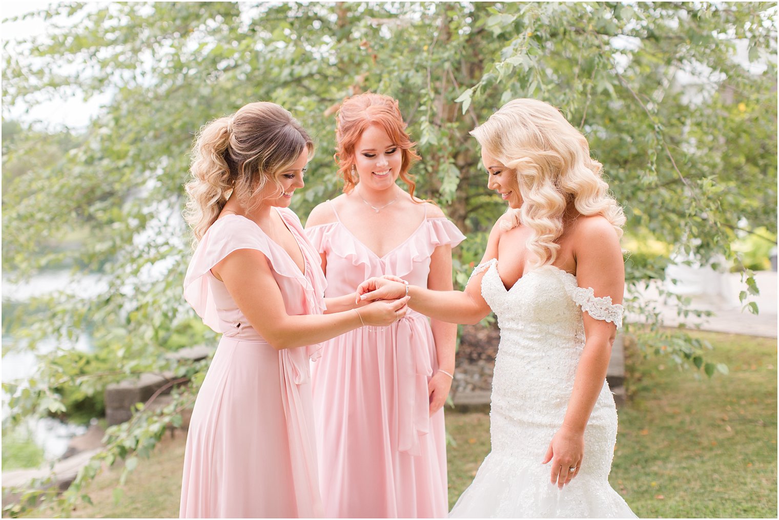 bridesmaids put bride's bracelet on before Windows on the Water at Frogbridge wedding