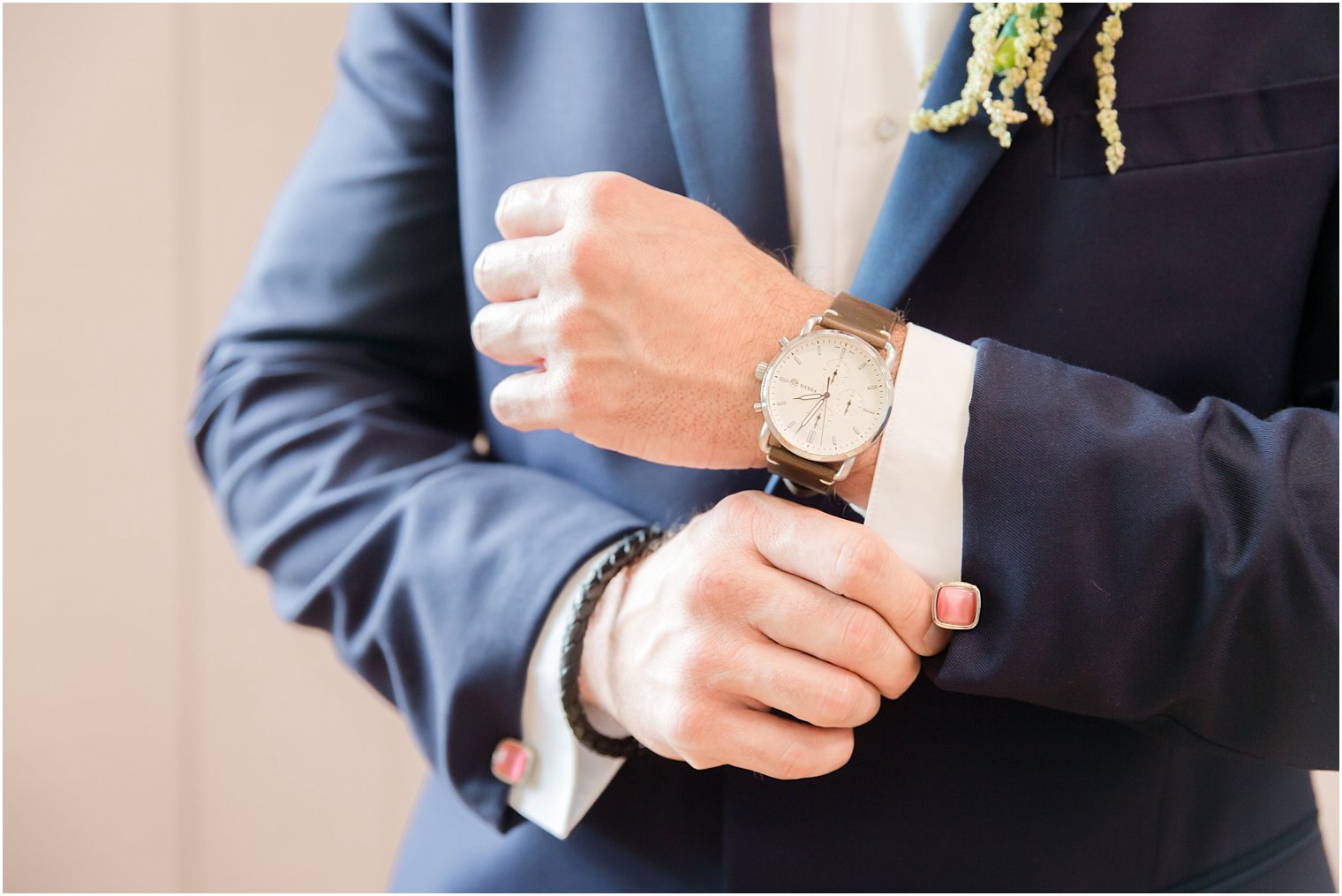 groom adjusts coral and gold cufflinks before Windows on the Water at Frogbridge wedding