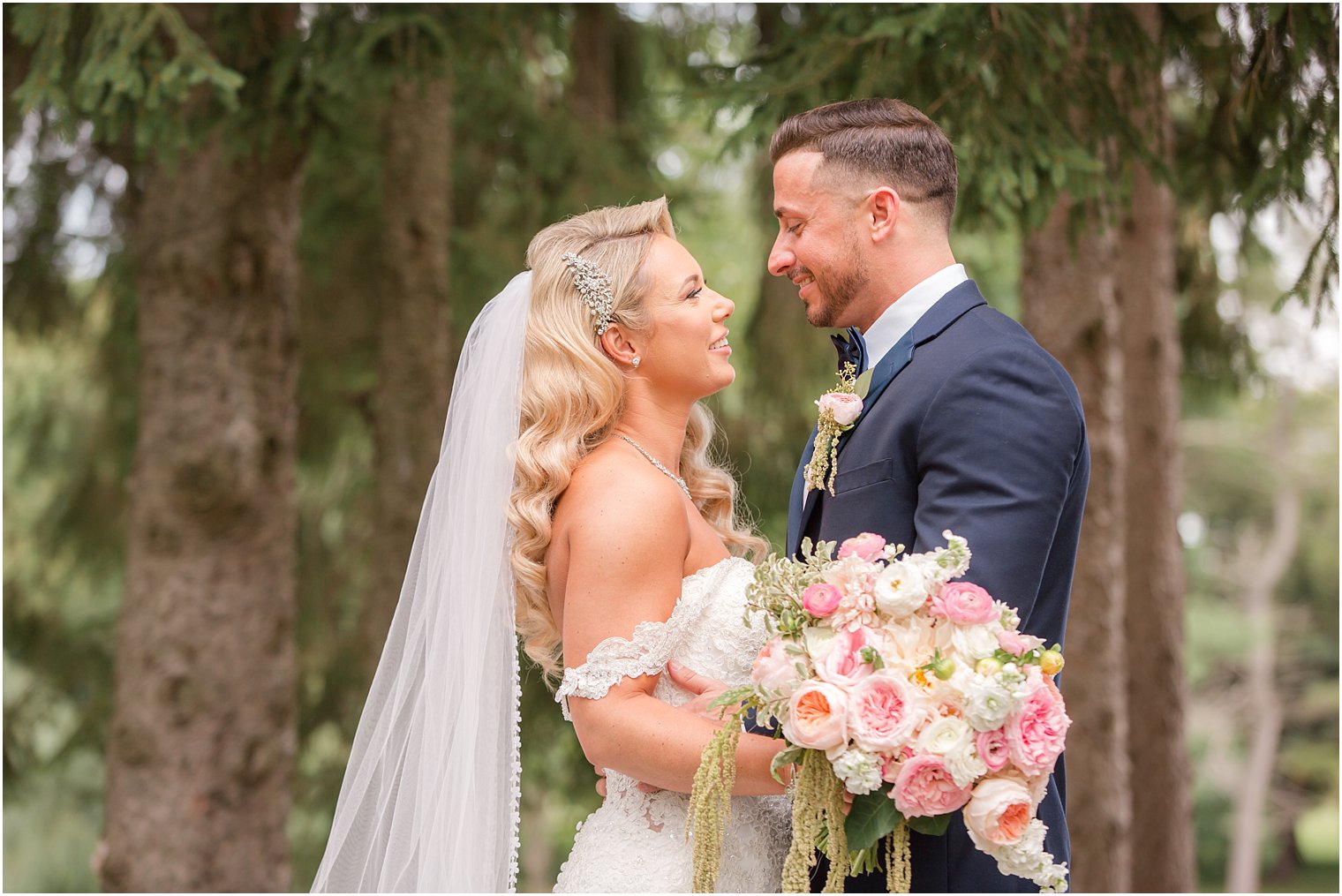 bride and groom smile during wedding portraits at Windows on the Water at Frogbridge