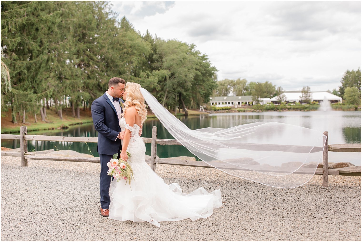 bride and groom kiss with veil in the air at Windows on the Water at Frogbridge