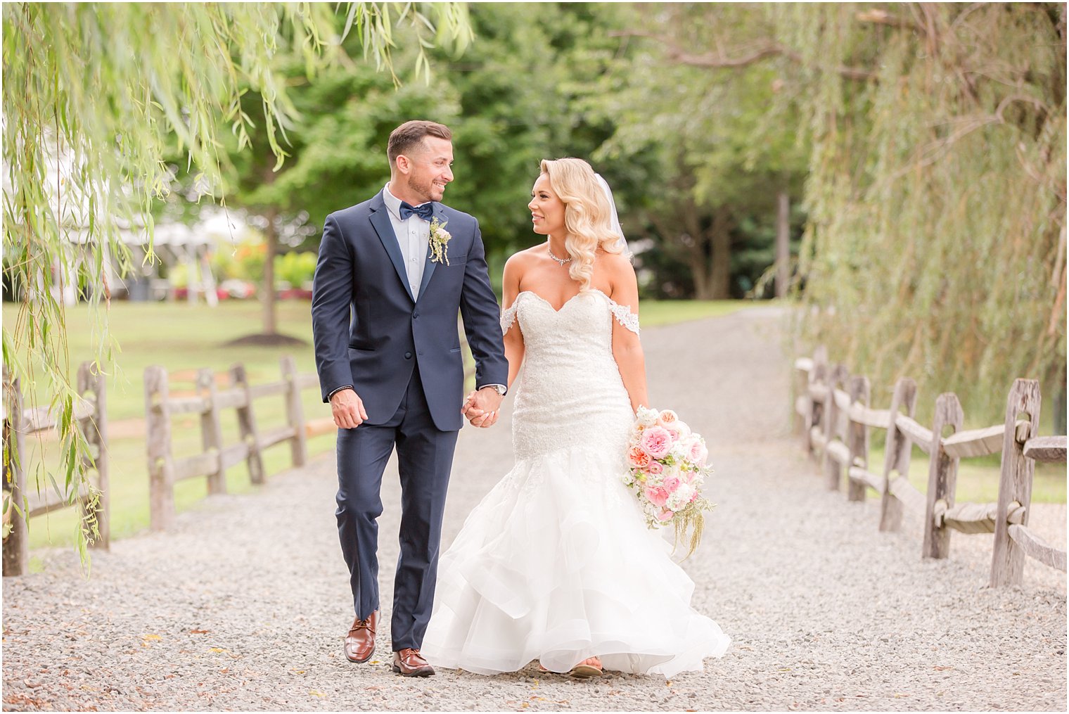 newlyweds walk along driveway at Windows on the Water at Frogbridge