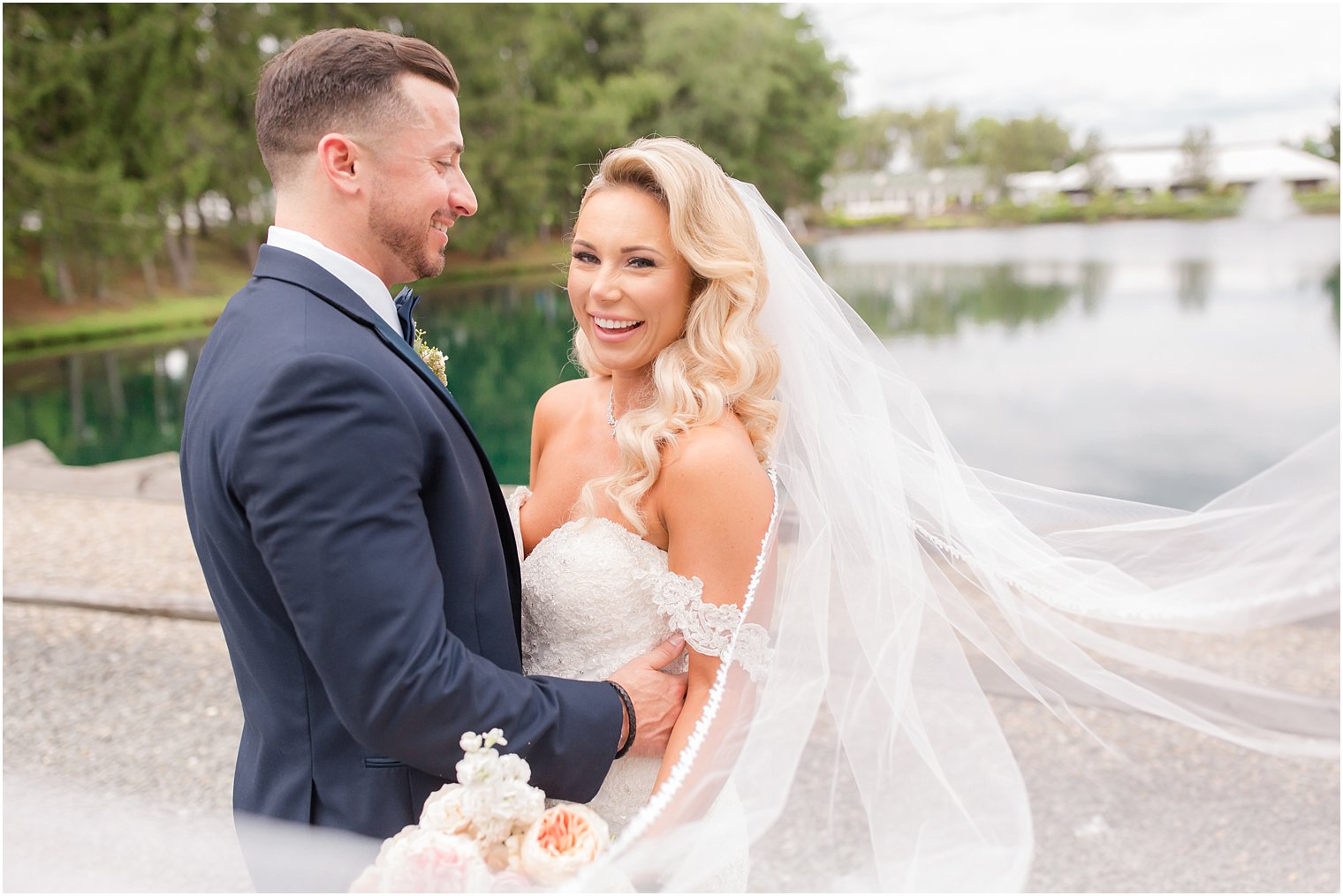 joyful bride laughs during wedding portraits at Windows on the Water at Frogbridge
