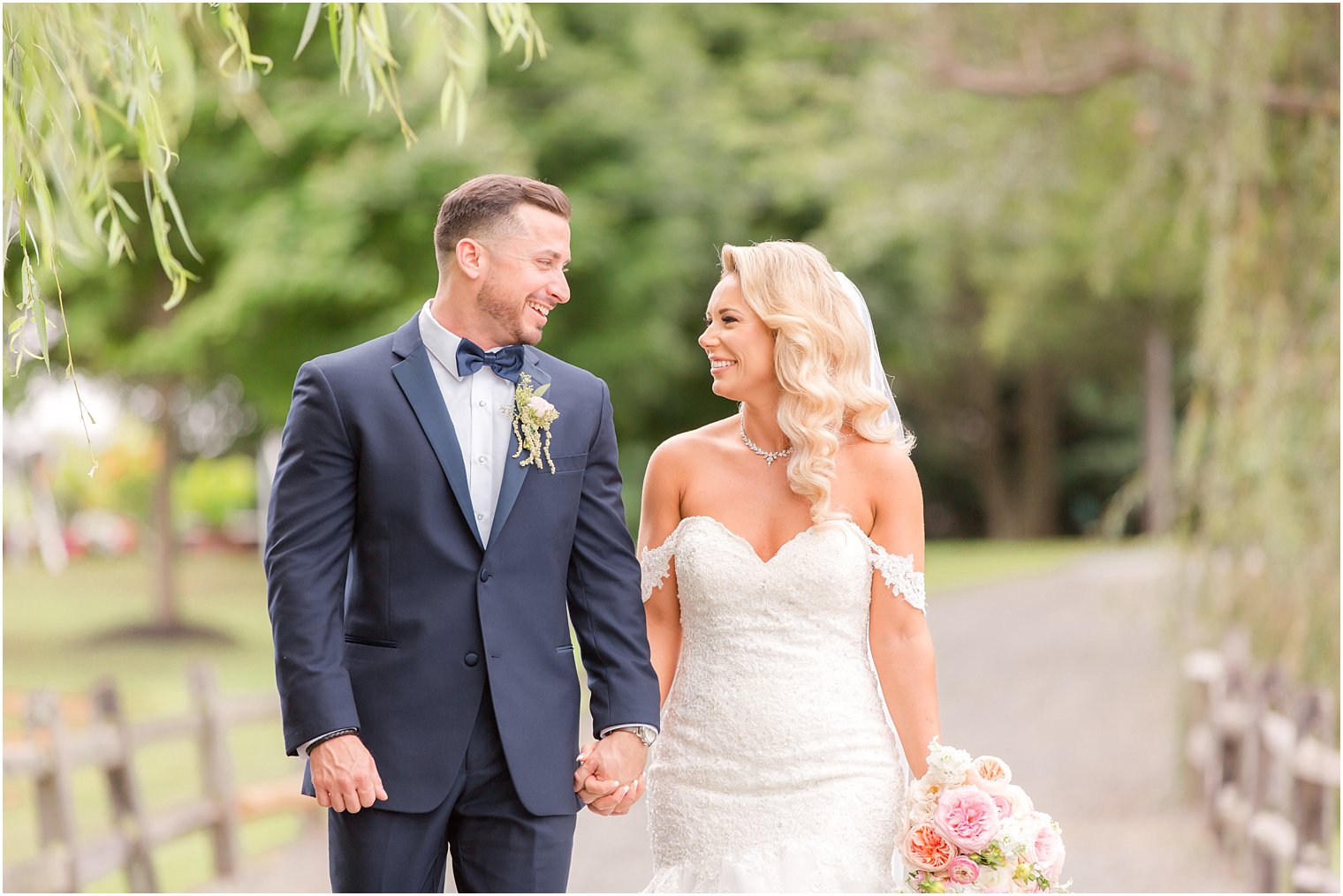 bride and groom smile at each other during portraits at Windows on the Water at Frogbridge