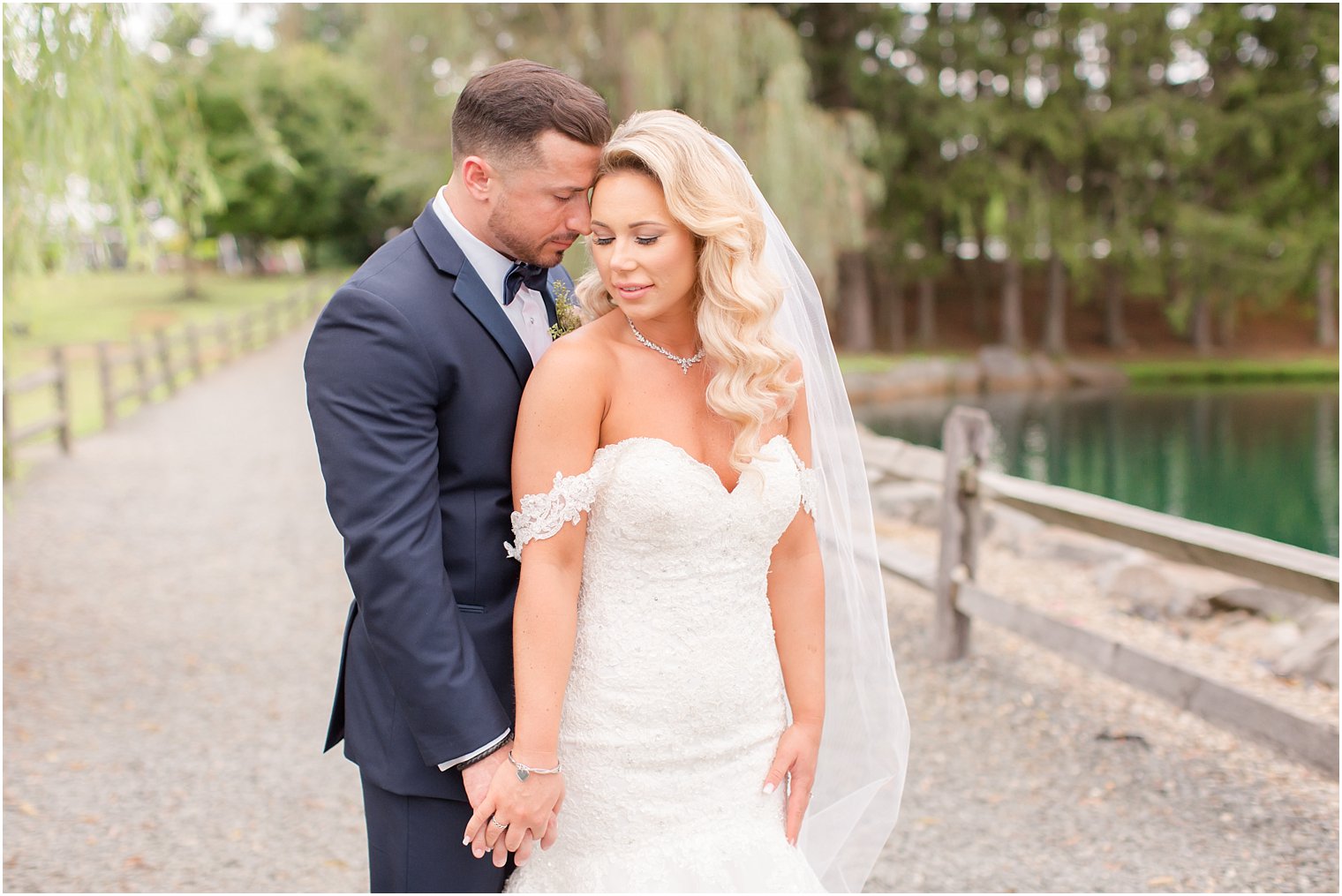 bride and groom pose with Idalia Photography during wedding portraits