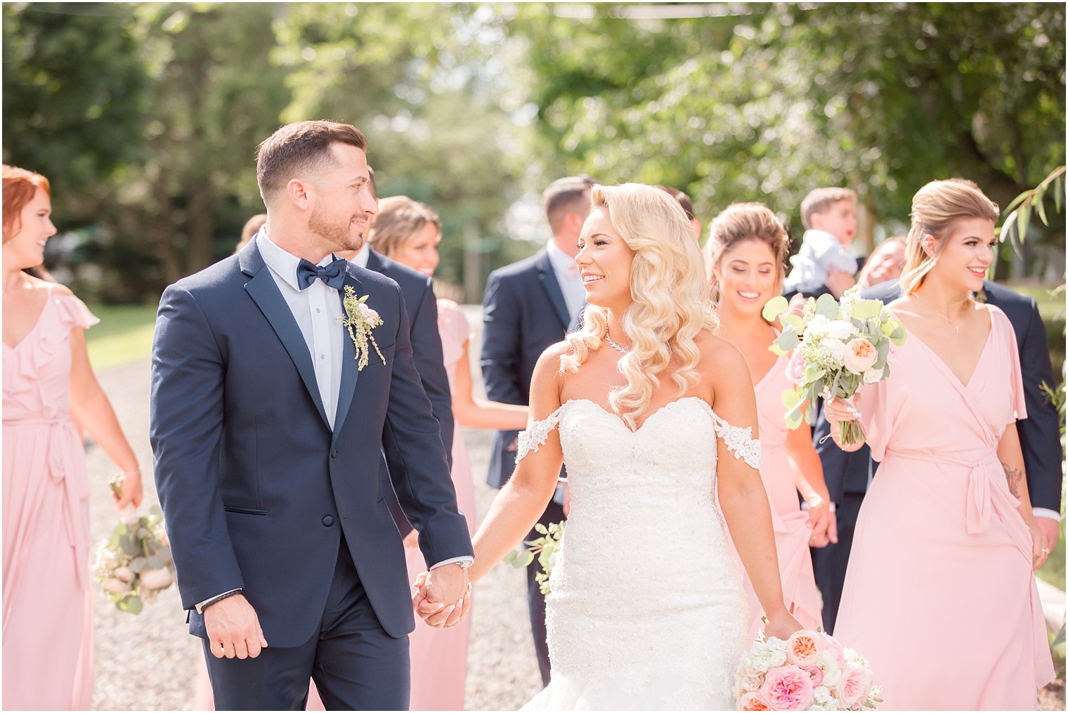 bride and groom smile in front of wedding party at Windows on the Water at Frogbridge