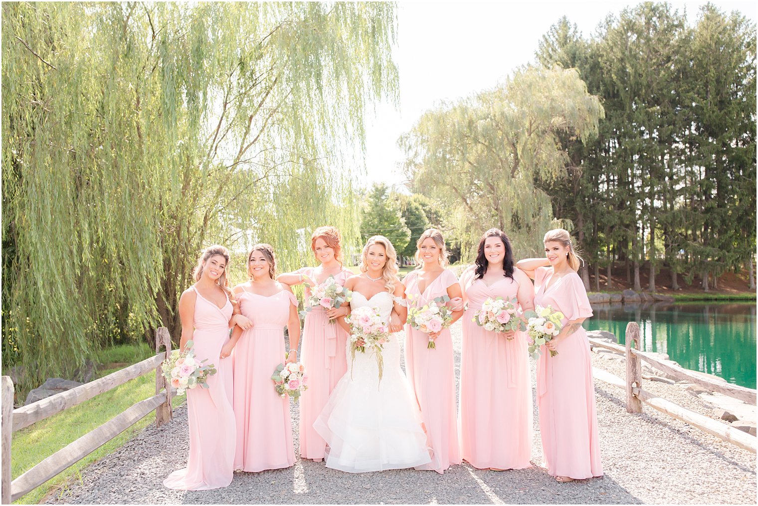 bridesmaids in light pink dresses with bride at Windows on the Water at Frogbridge