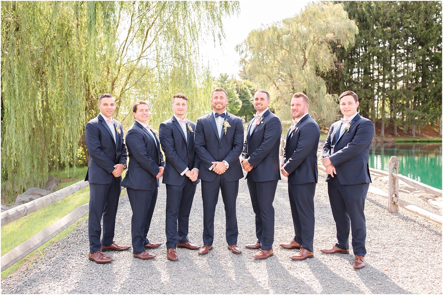 groom and groomsmen in navy suits at Windows on the Water at Frogbridge