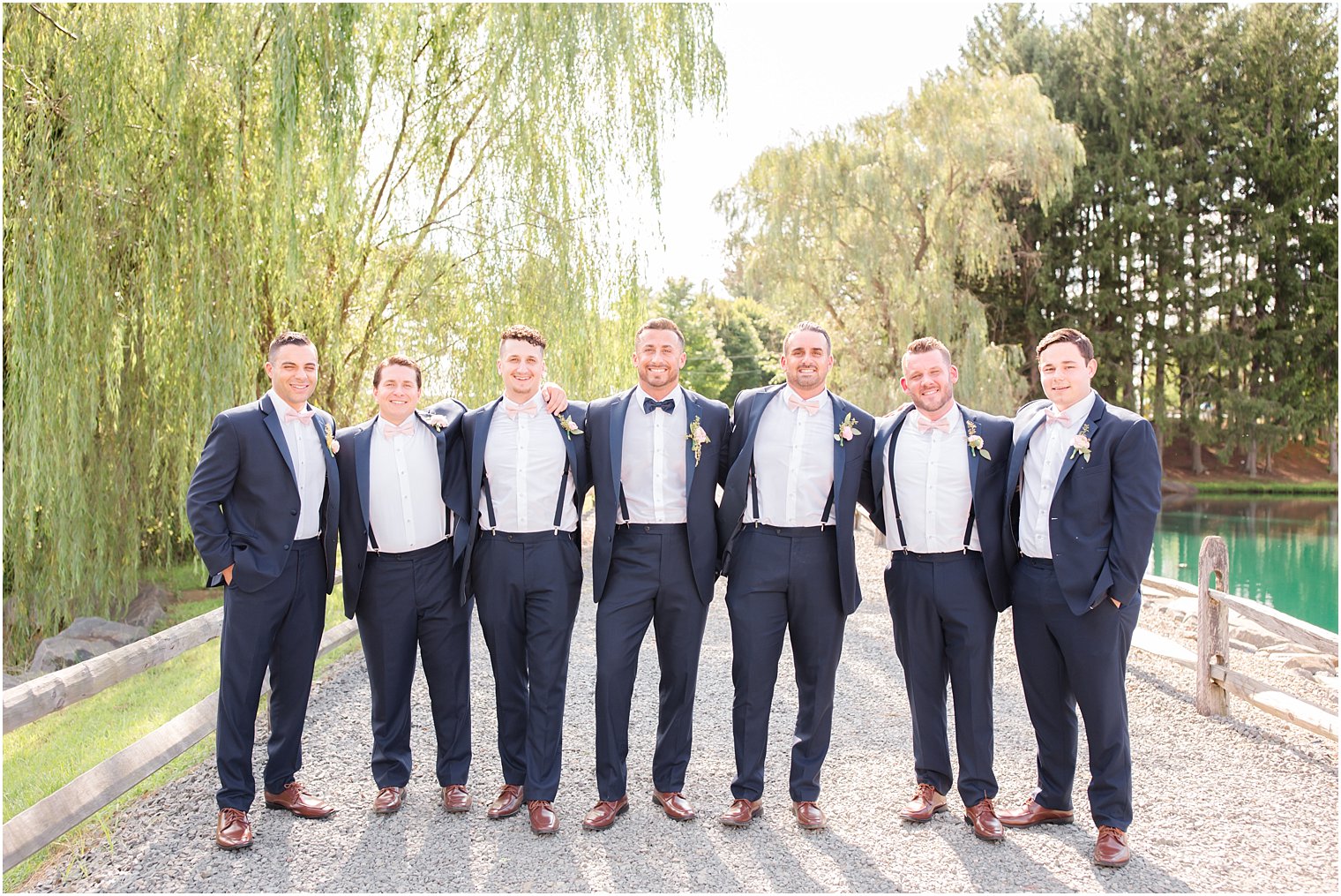 groomsmen show off suspenders during portraits with Idalia Photography