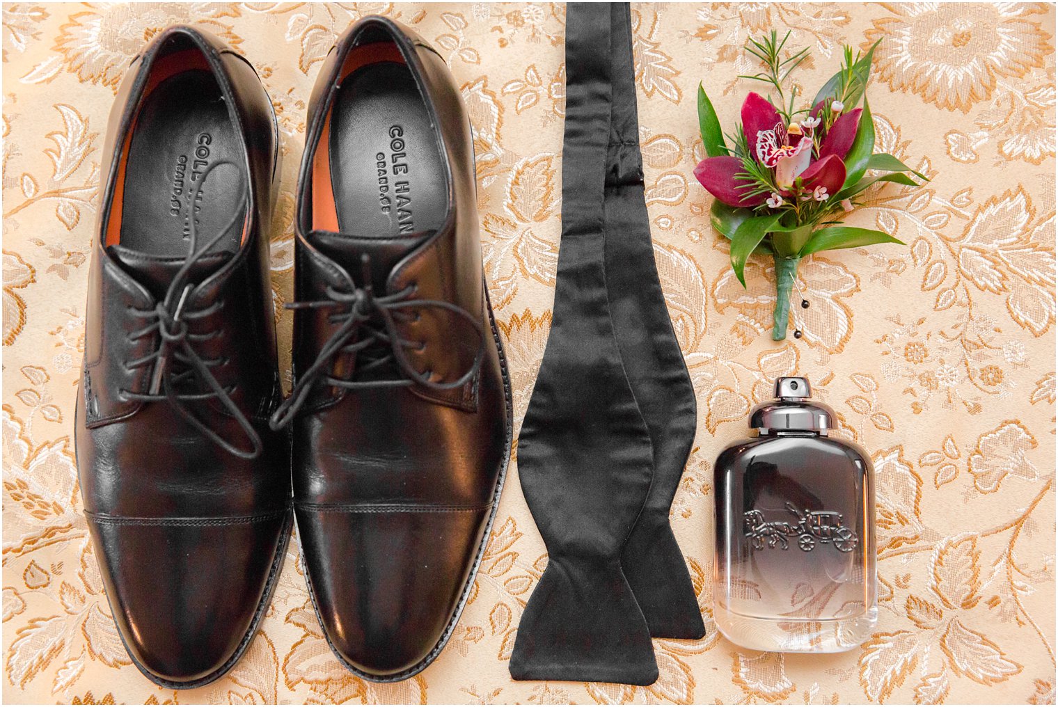 Groom's wedding shoes, black tie, cologne, and boutonniere