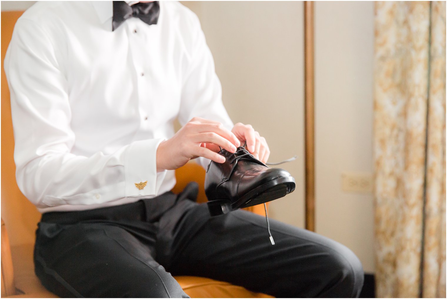 Groom putting on his shoes on wedding day