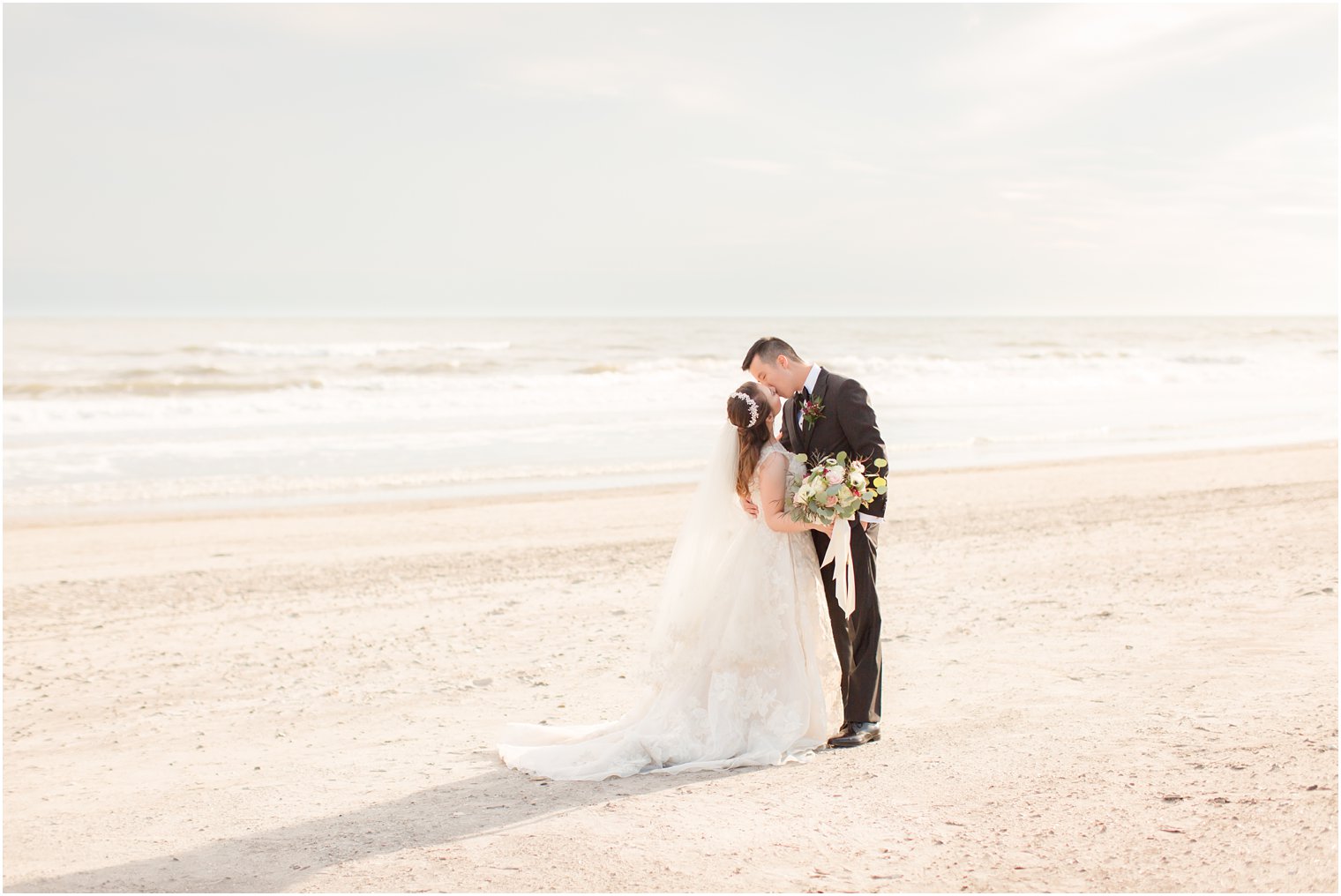 Bride and groom kissing on the beach in Atlantic City