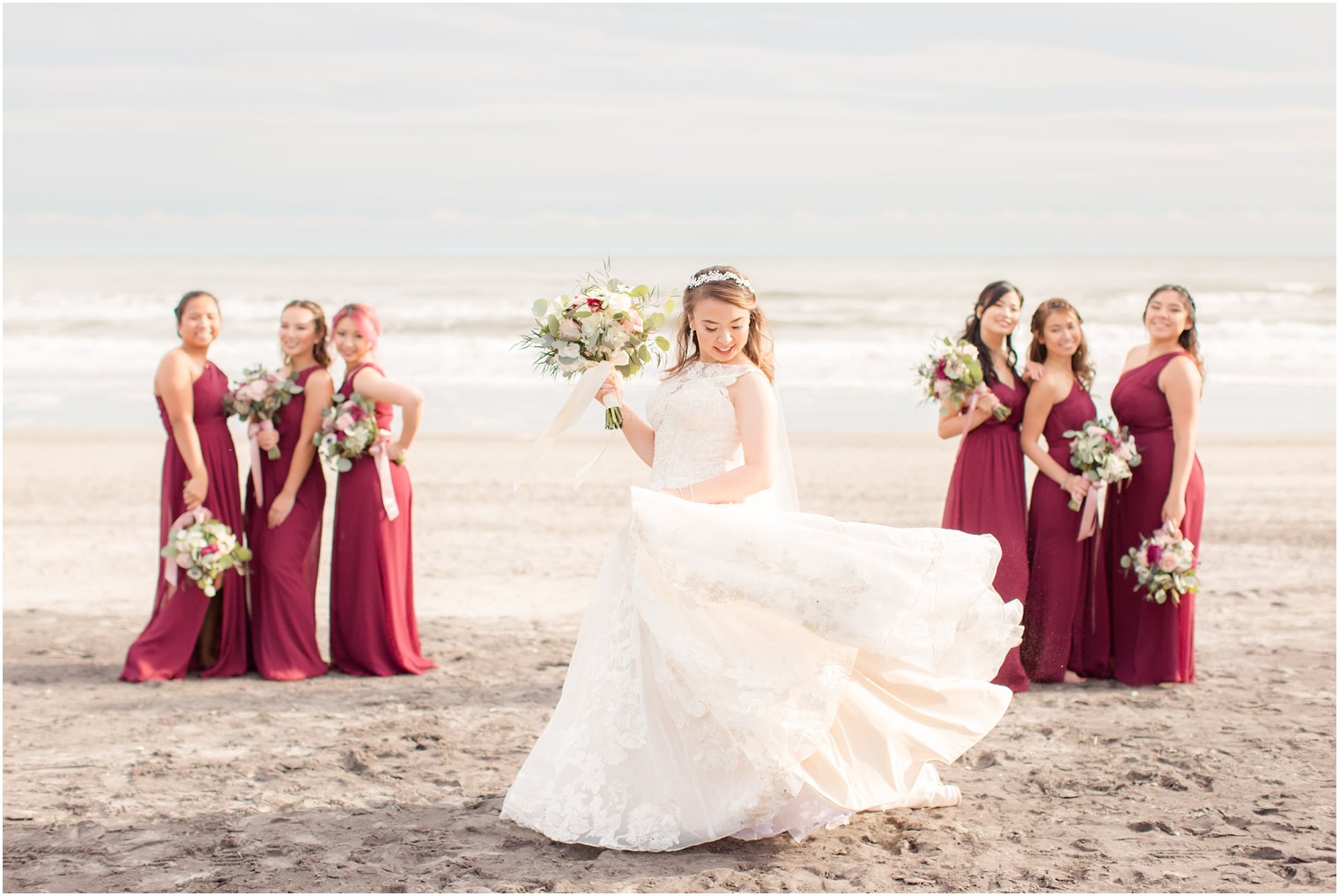 Bridesmaids on the beach wearing burgundy dresses