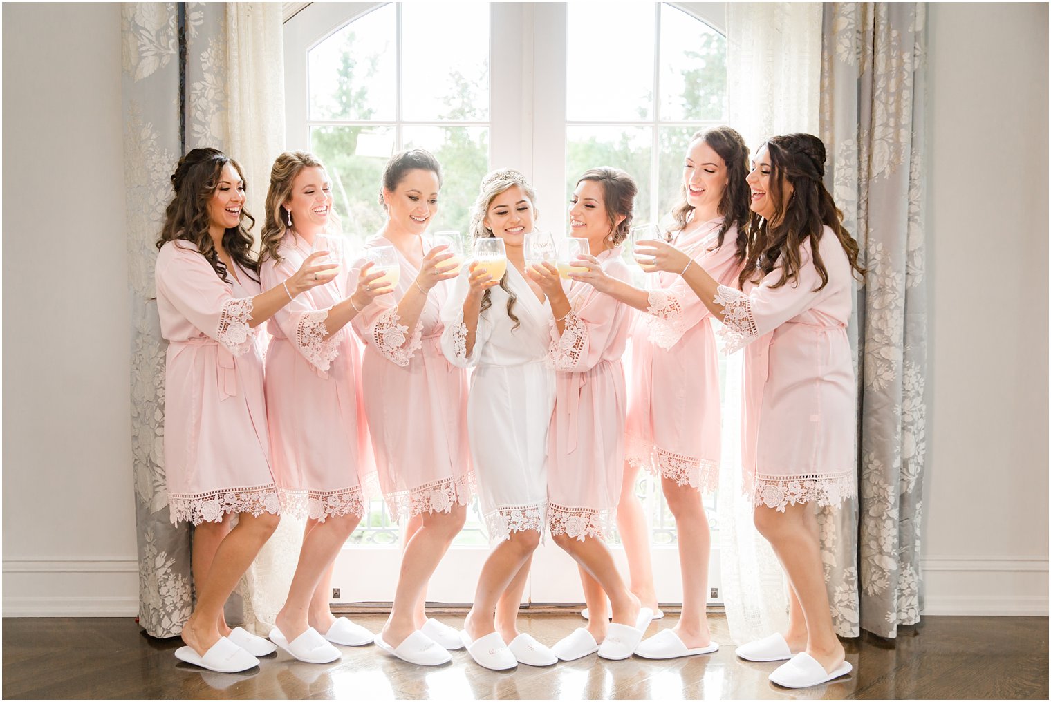 Bride and bridesmaids in robes toasting with champagne