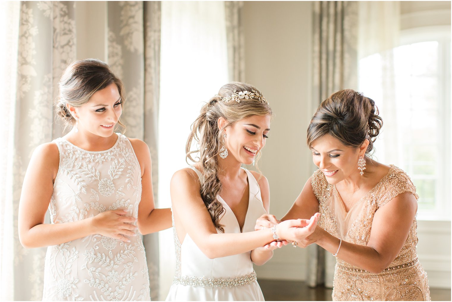 Mother putting on bride's bracelet on her wedding day