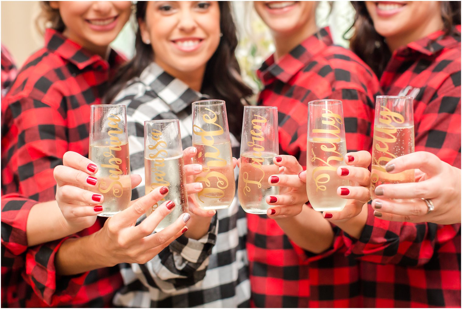 bride and bridesmaids hold champagne glasses photographed by Idalia Photography