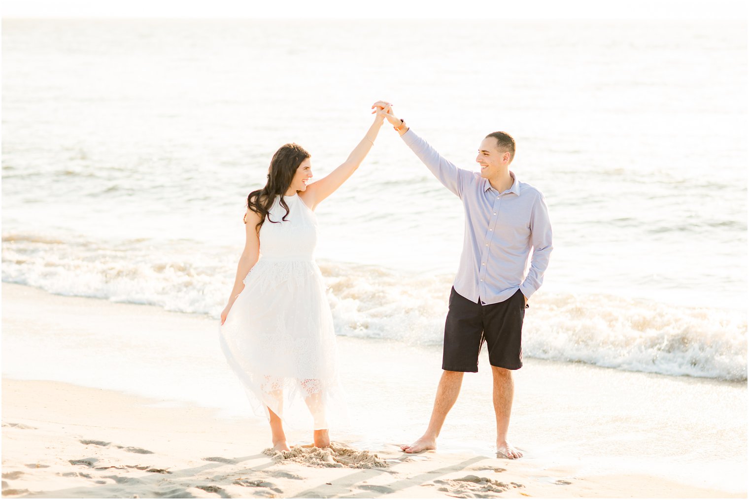 Groom twirling bride during beach portraits