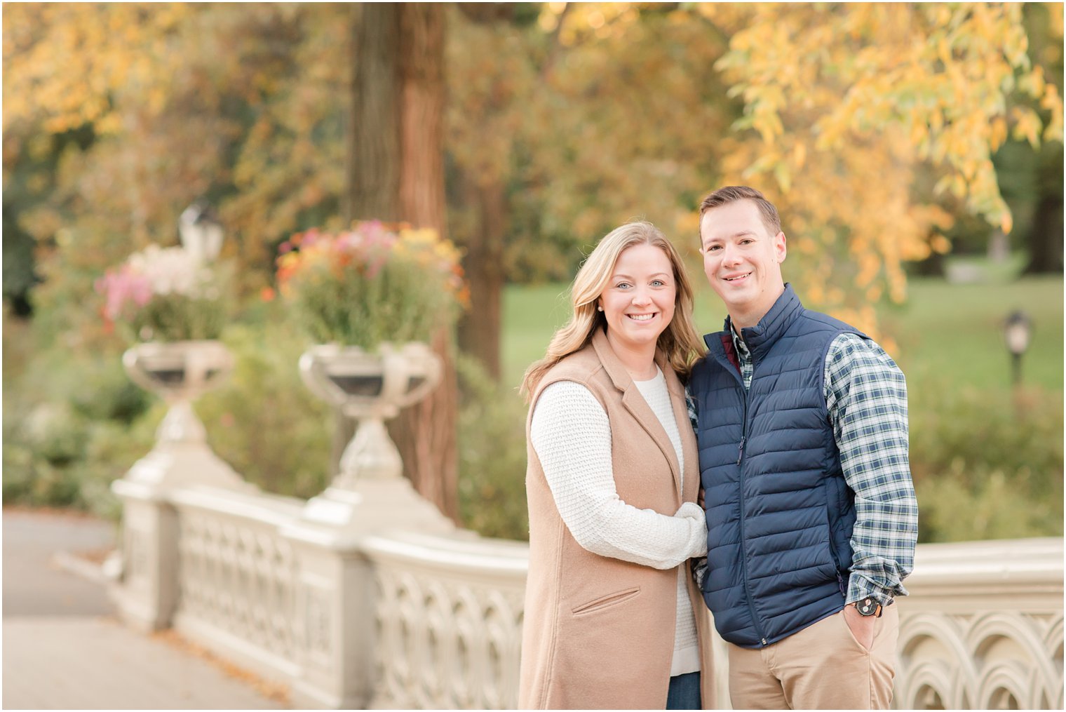 Engaged couple posing for photos on Bow Bridge