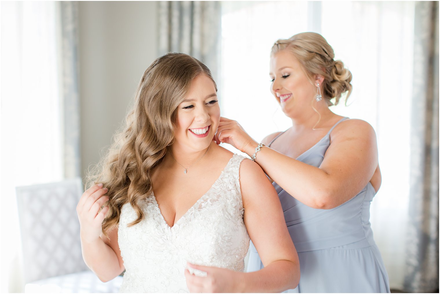 bride getting dressed with maid of honor at Park Chateau Estate in East Brunswick, NJ