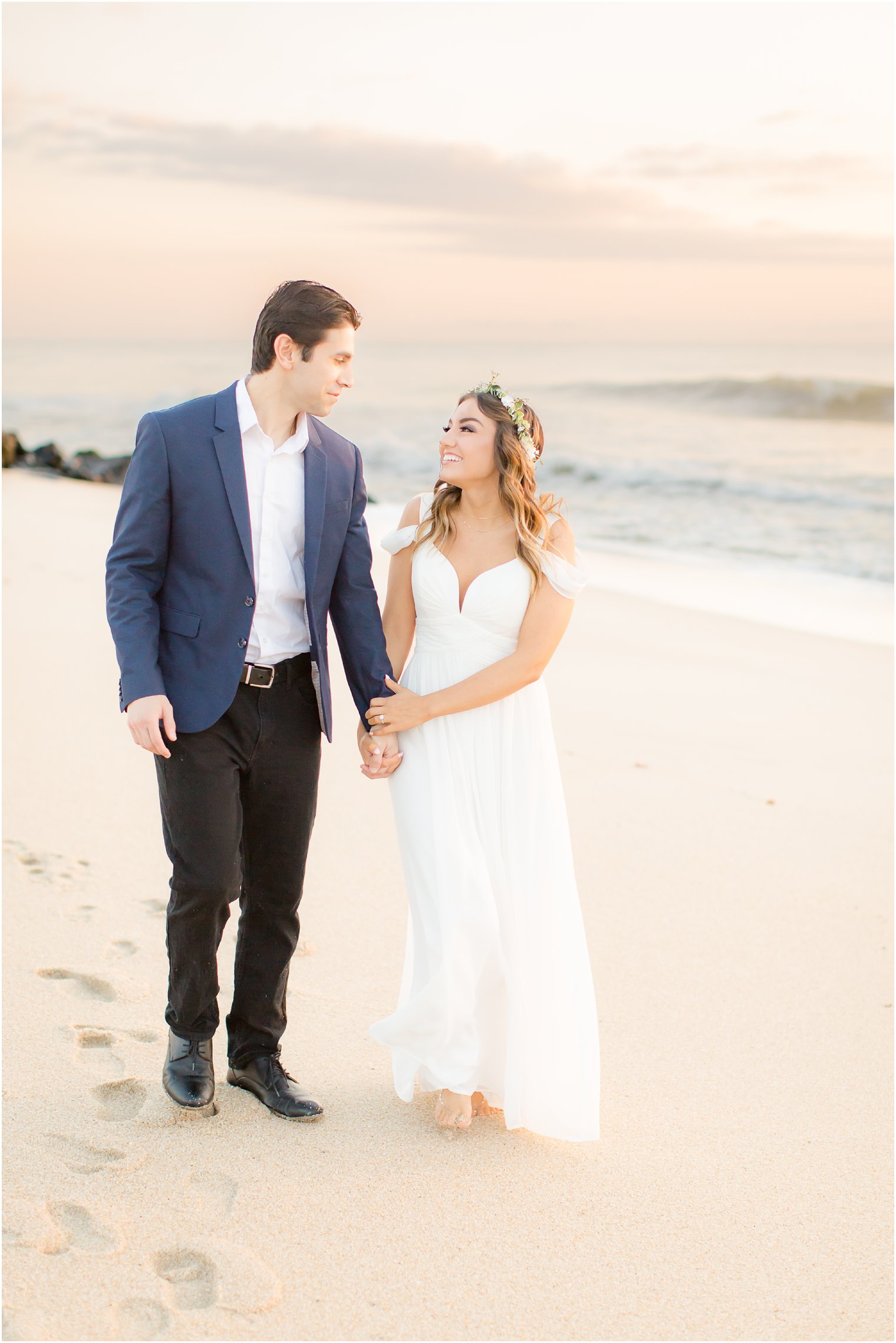 engaged couple walking on the beach at sunrise