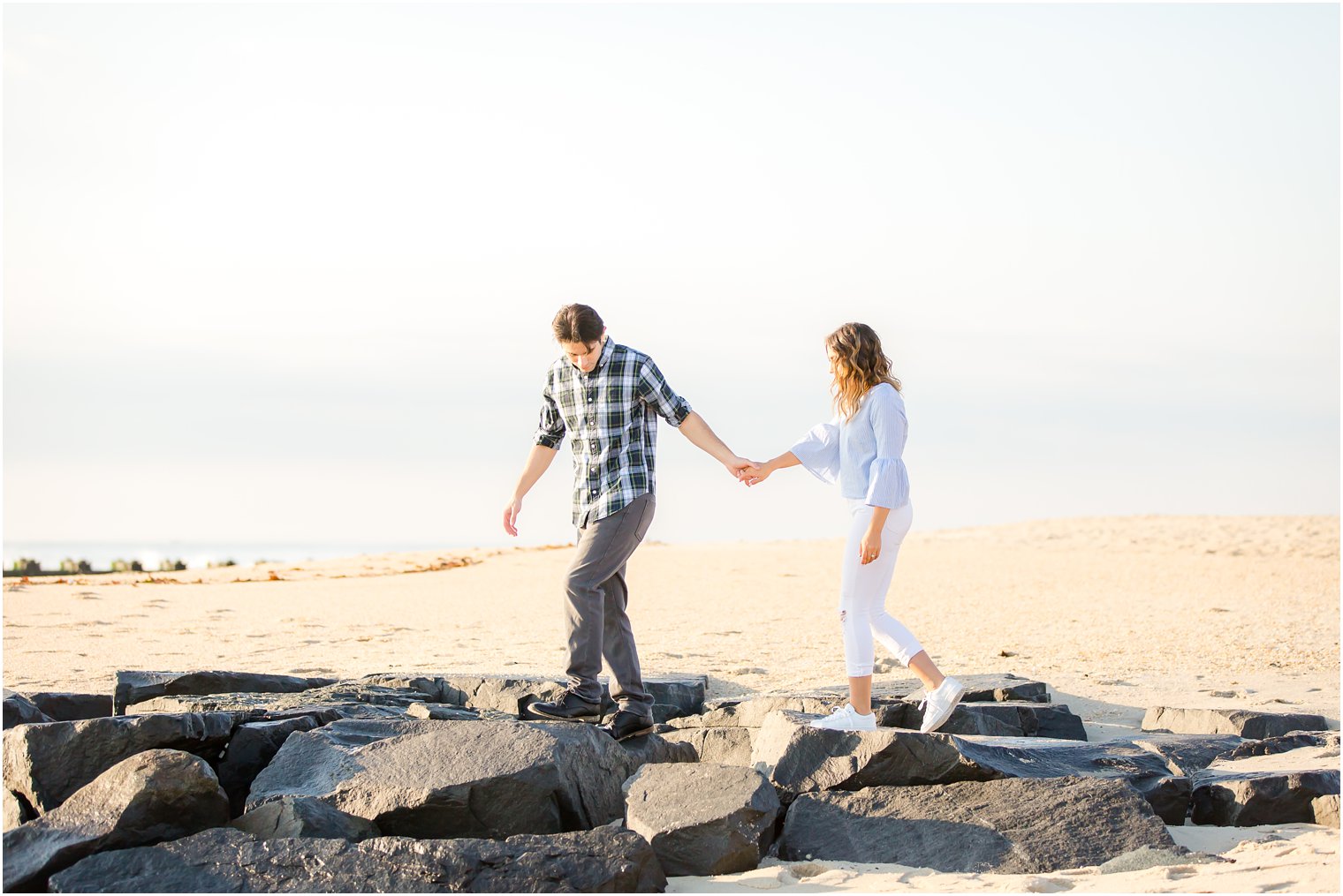 engaged couple walking on a jetty