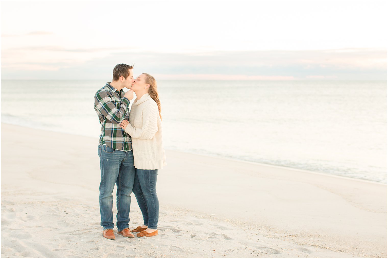 bride and groom kissing on the beach in Lavallette