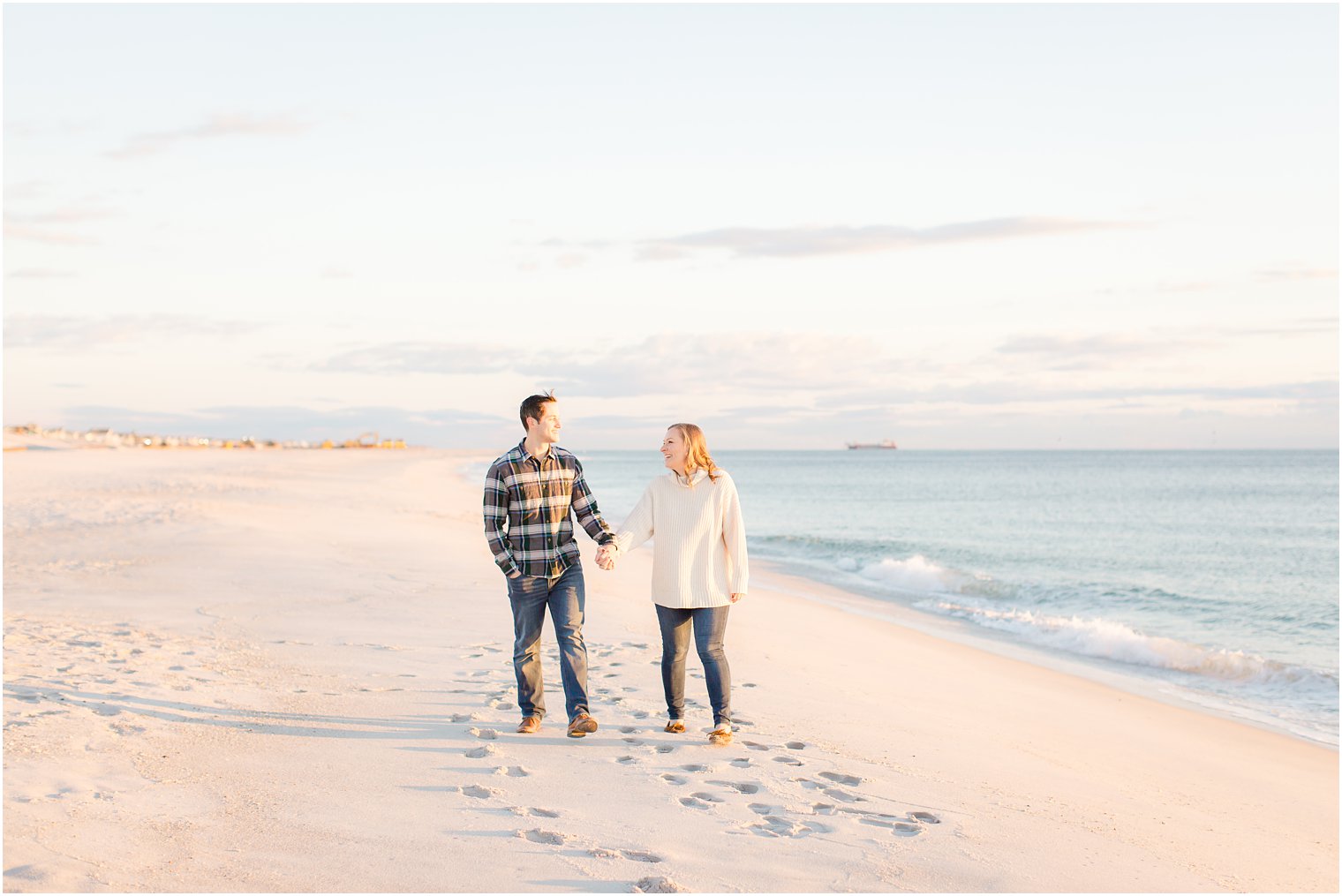 engaged couple walking on the beach after sunrise