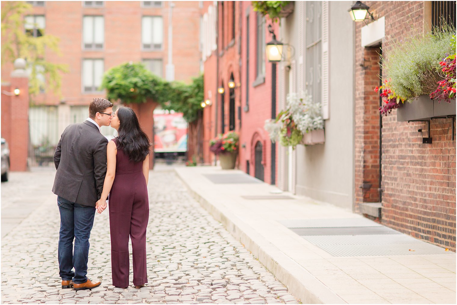 couple walking on cobblestone streets on NYU campus