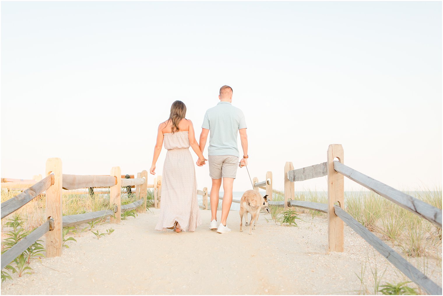 engaged couple walking their dog on the beach on LBI 