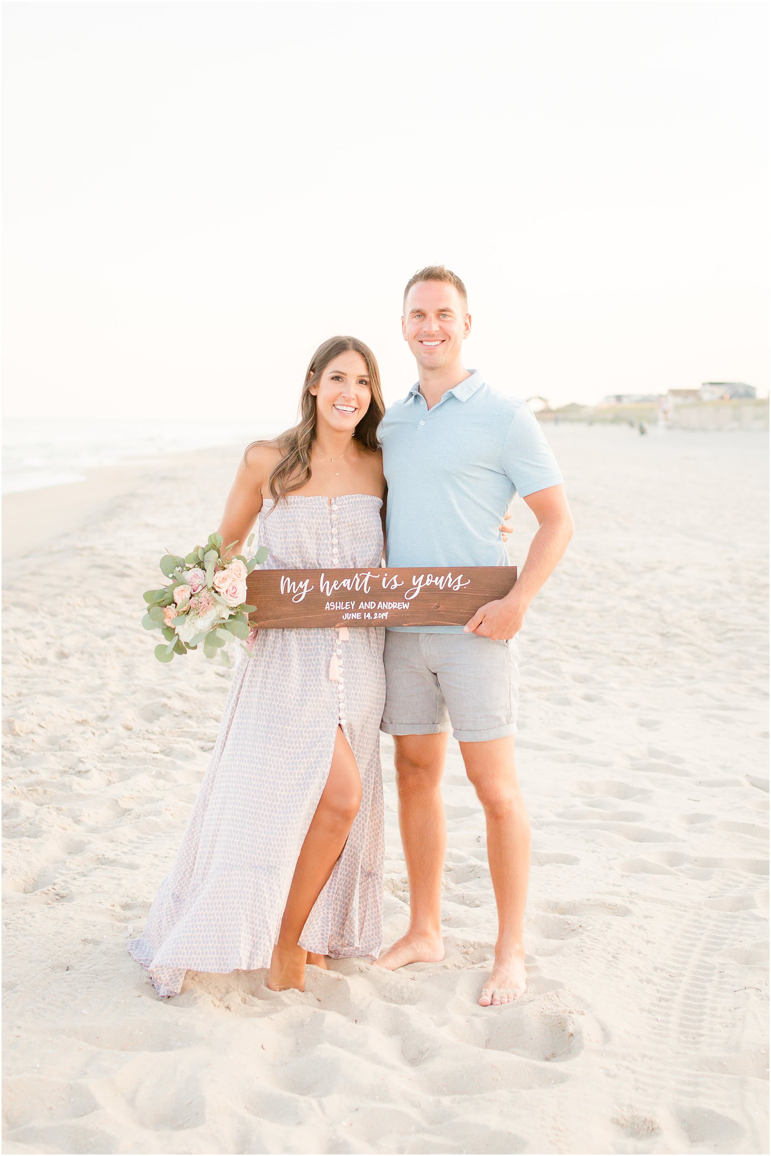 engaged couple holding calligraphy sign by The Shaded Maple