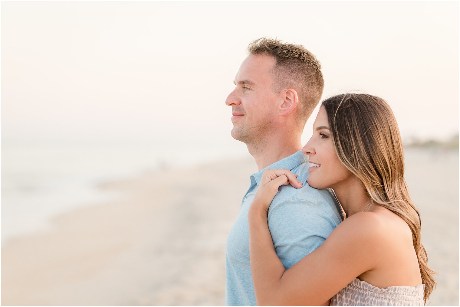 engaged couple looking out into the water