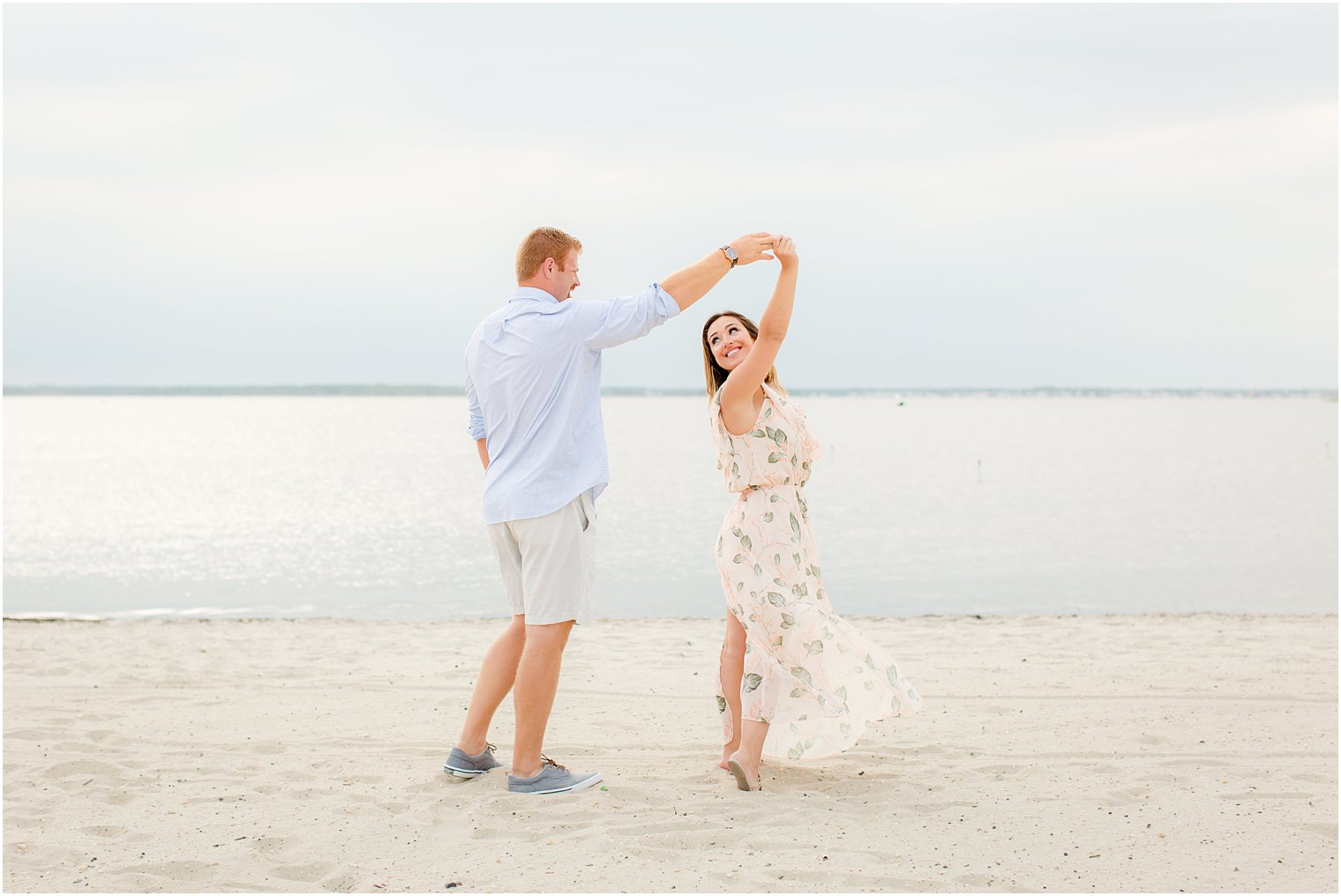 candid engagement photo with groom twirling bride