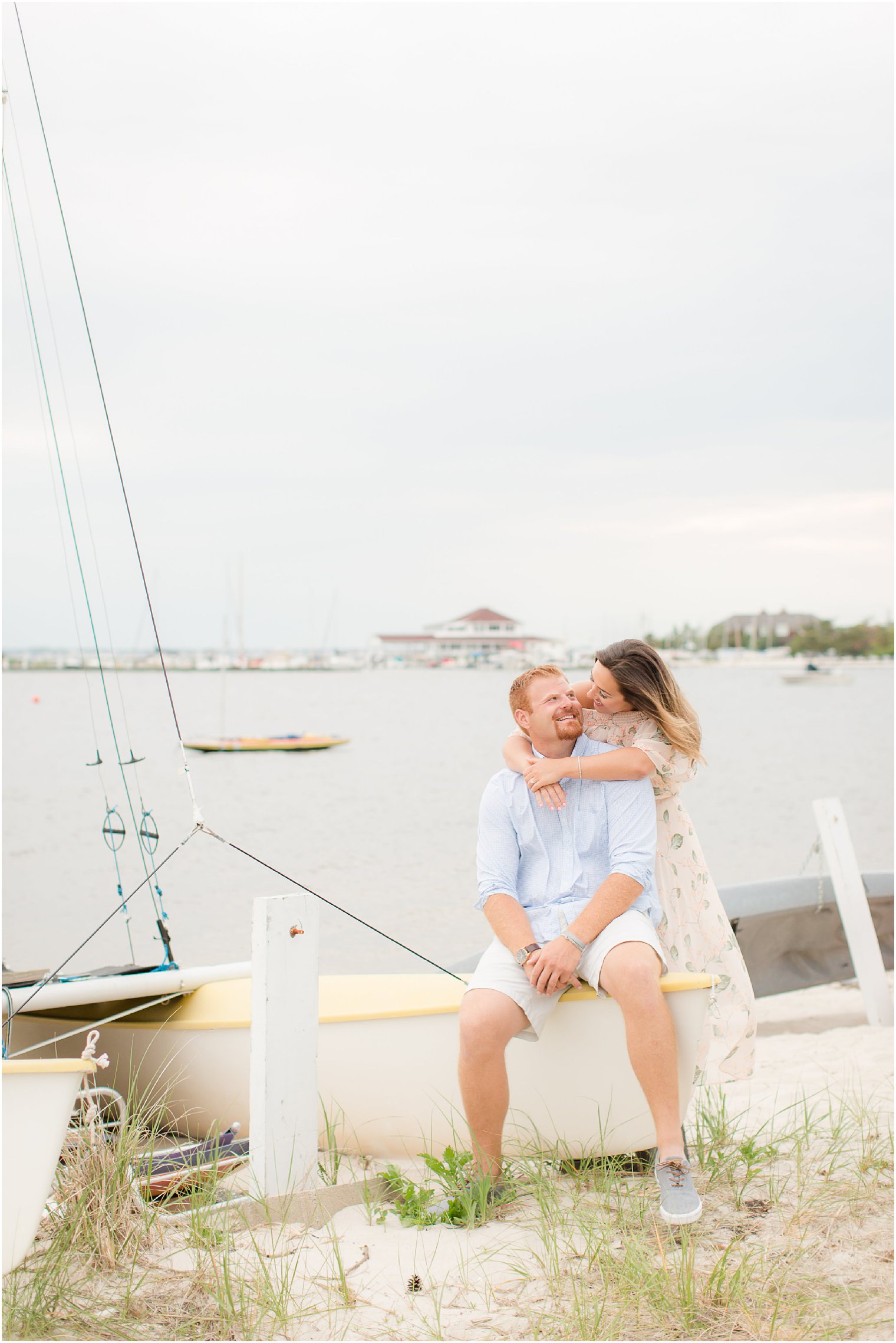 Young couple posing for engagement photos on a sailboat in Lavallette NJ 