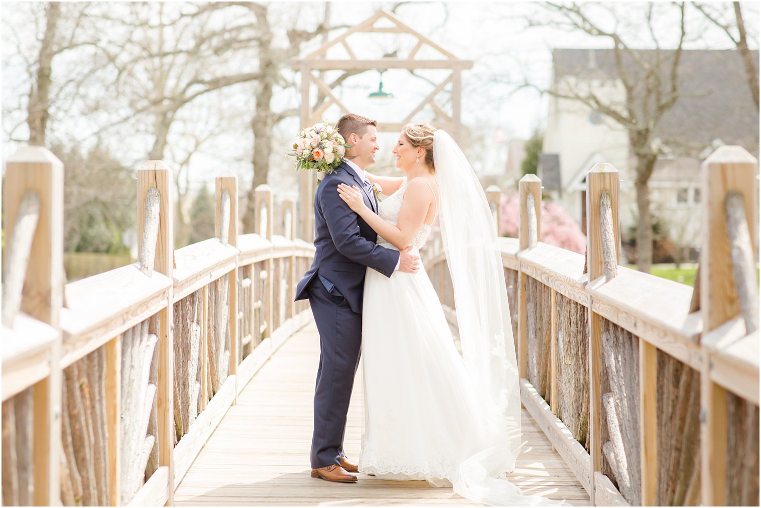 Bride and groom portraits on bridge at Divine Park in Spring Lake 