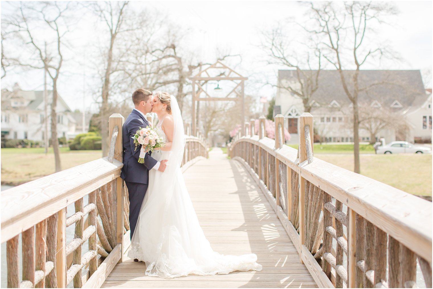 Bride and groom kissing on bridge at Spring Lake