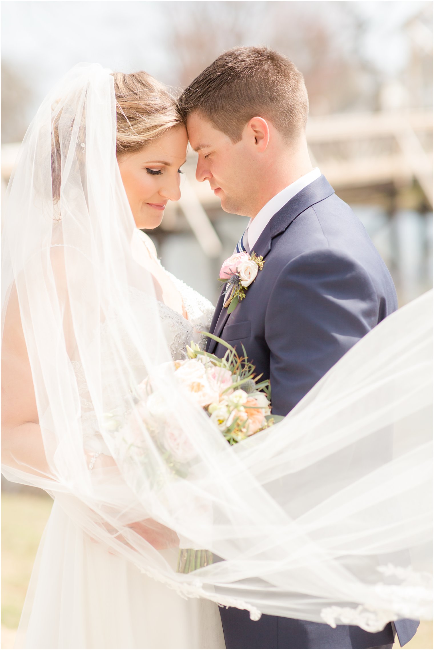 Romantic photo of bride and groom with wind blown veil 