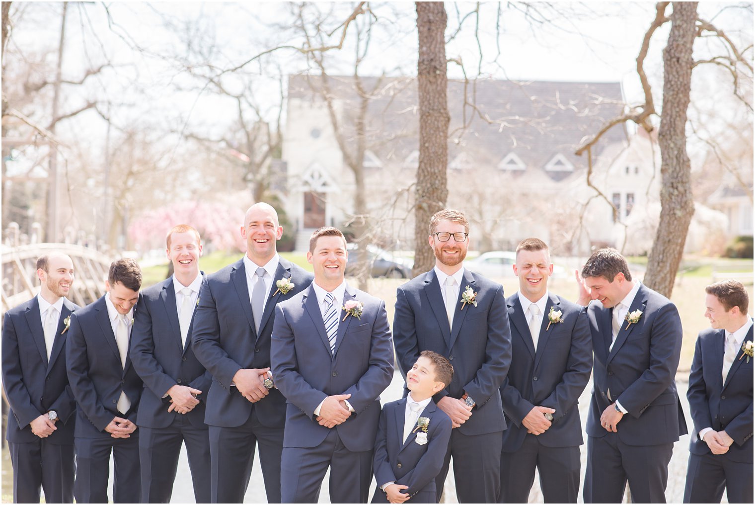 Groom and groomsmen laughing during portraits 