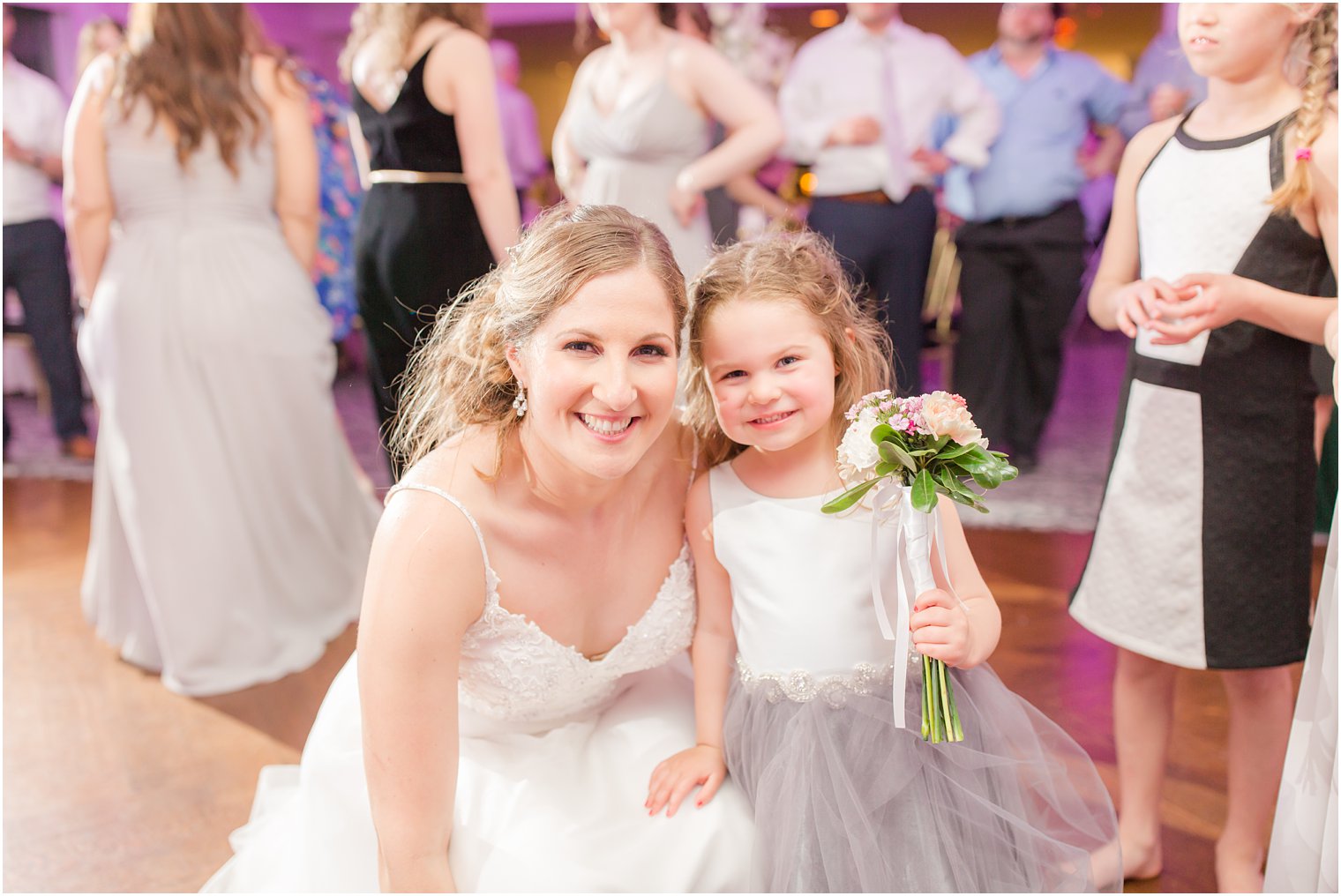 Flower girl catching bouquet during wedding reception at The Mill at Lakeside Manor in Spring Lake NJ