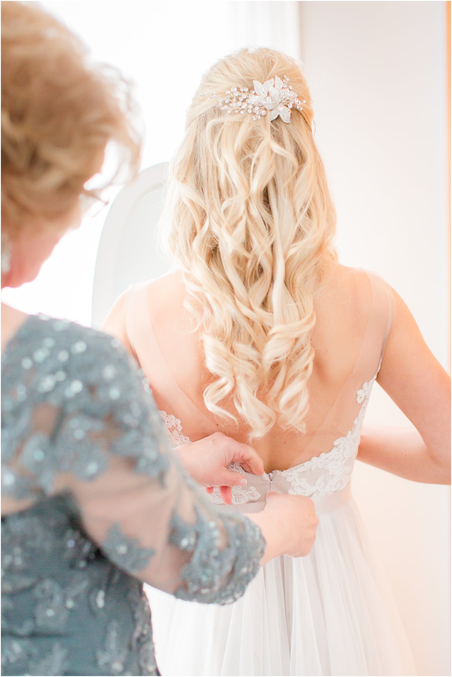 bride getting ready with her mother on wedding day