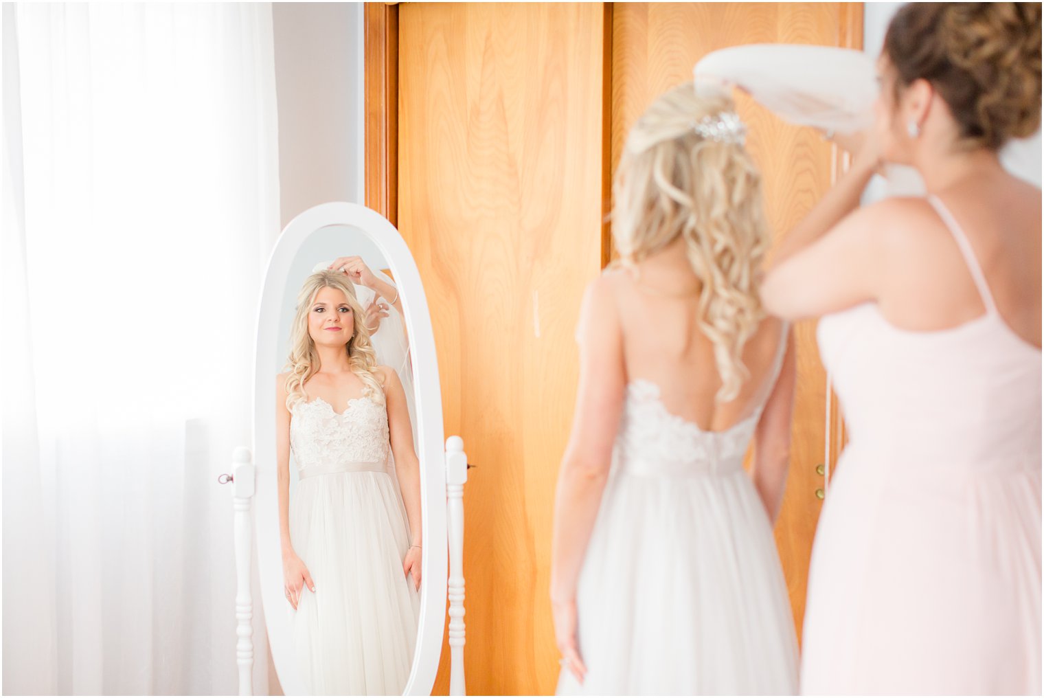 maid of honor putting on bride's veil